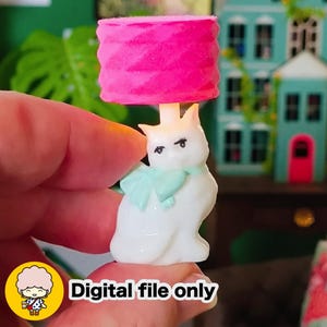 May include: A miniature white cat-shaped lamp with a pink lampshade and a light blue scarf. The lamp has a crown and the text "Digital file only" is visible.