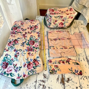 May include: A floral print travel set featuring a large garment bag, a rectangular toiletry case, a hanging organizer with clear pockets, and a small zippered pouch. A yellow measuring tape shows the garment bag is 36 inches in length.