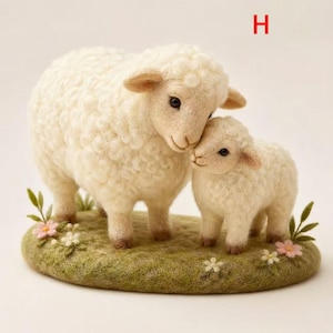 Op de afbeelding: Een handgemaakte wollen sculptuur van een moeder schaap en haar lam, staand op een groene grasbasis met kleine bloemen. De schapen zijn wit met gedetailleerde kenmerken, wat een charmante pastorale scène creëert.