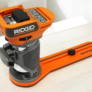 May include: An orange and gray RIDGID brushless router with a black battery compartment. The router is mounted on an orange base with the text "ROKATONG". The tool is designed for woodworking and carpentry.