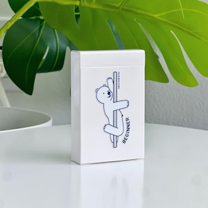 A white rectangular deck box featuring a cartoon polar bear on a pole, with the word "BEGINNER".