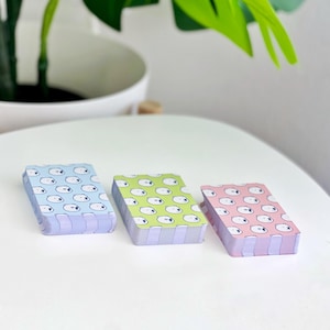 The backs of the three levels of card decks. Blue is for beginner, green is for intermediate, and red is for advanced.
