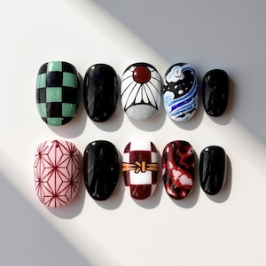 May include: A set of ten artificial nails with various designs. The designs include a green and black checkered pattern, solid black, a white and red sun, a wave pattern, a pink geometric pattern, and a red and white pattern.