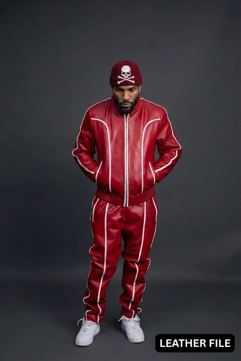 May include: A red leather tracksuit with white trim, featuring a zip-up jacket and matching pants. The outfit is paired with a maroon beanie with a skull and crossbones design. White sneakers complete the look. The text "LEATHER FILE" is visible.