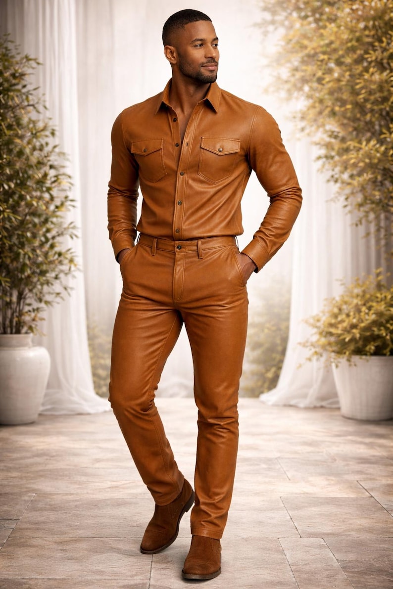 May include: A full-length shot of a person wearing a brown leather shirt and pants set. The shirt has two chest pockets and button closures. The pants are fitted. The person is also wearing brown suede boots.