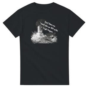 May include: Black t-shirt featuring a grayscale illustration of a graveyard scene with a tombstone and the text "Don't blame me... I didn't vote for ANY of the Crypt-Keepers." The design is centered on the shirt.