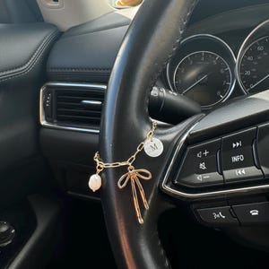 ステアリングホイール、シフター用のイニシャル、パール、チェリーのチャームが付いたリボン