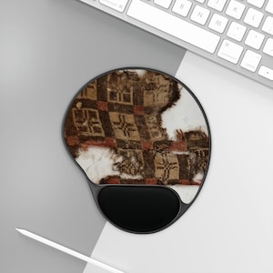 May include: Ergonomic mouse pad with a black wrist rest and a circular design. The pad features a distressed textile pattern in shades of brown, red, and white, resembling a vintage fabric or rug.