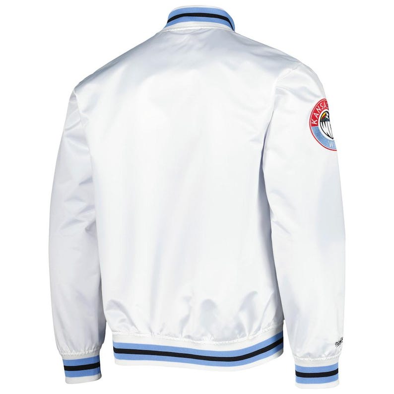 Puede incluir: Una chaqueta bomber de sat&eacute;n blanco con cuello alto y ribetes a rayas en azul claro y negro. Los pu&ntilde;os y el dobladillo tambi&eacute;n muestran rayas a juego en azul claro y negro. Un parche circular con texto en rojo, blanco y azul est&aacute; en la manga izquierda.