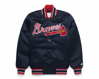 May include: Navy blue satin jacket with red and white trim. The jacket features the word "Braves" in red script with a matching tomahawk logo. The jacket has a snap-button closure and ribbed cuffs and hem.