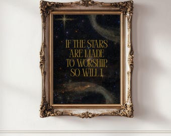 May include: A framed print with a celestial theme. The artwork features a dark blue and black starry night sky with a gold-colored star and swirling nebulas. Gold text reads, "IF THE STARS ARE MADE TO WORSHIP, SO WILL I." The frame is ornate and gold-colored.
