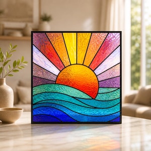 May include: Square stained glass panel depicting a sunset over the ocean. The sun is a vibrant orange and yellow, with rays of orange, pink, and purple. The ocean is blue and green, with stylized waves. The panel is framed in black.