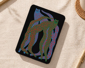 May include: Black rectangular case featuring a colorful illustration of three abstract figures. The figures are in shades of blue, green, and red, with a dotted pattern. The case is on a neutral-toned surface.