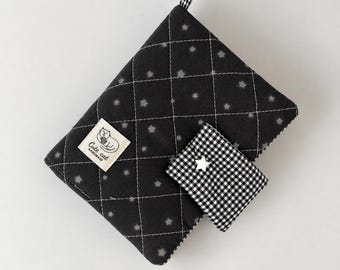 May include: A black quilted fabric pouch featuring a white diamond stitch pattern and small grey star motifs. A rectangular label reads Cute cat HANDMADE. A smaller black and white gingham pocket is attached, accented with a silver star-shaped stud.
