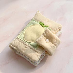 May include: A quilted oven mitt and matching pot holder set. The mitt features a lemon applique on a green background, with a light yellow quilted pattern. The pot holder has a white star. The set is in shades of yellow and green.