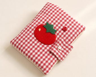 May include: A rectangular notebook cover featuring a red and white gingham pattern. A red felt tomato appliqué with a green stem is centred on the front. A small matching gingham flap with a white star button and a tiny red heart button are attached.