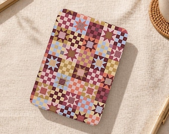 May include: A rectangular tablet case with a colorful patchwork design. The pattern features squares and star shapes in shades of pink, blue, yellow, and brown. The case is likely made of a durable material to protect the tablet.