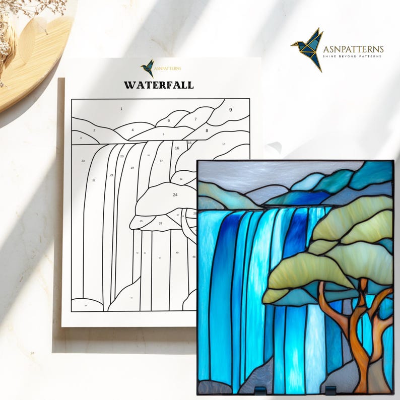 May include: A stained glass panel and a line drawing of a waterfall. The stained glass features a waterfall with blue water, green and yellow trees, and grey mountains. The line drawing is labelled "WATERFALL" and has numbered sections.