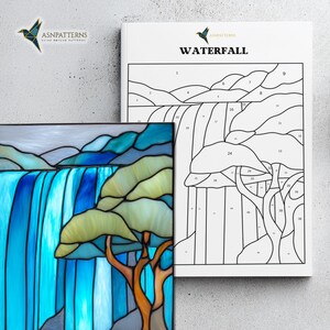 May include: A stained glass panel and a pattern book titled "Waterfall". The panel shows a waterfall in blue and green tones, and a tree with an orange trunk. The book features a line drawing of the same waterfall design.