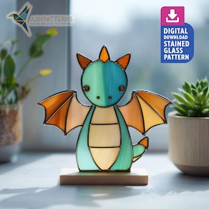 May include: A stained glass dragon figurine in shades of teal, orange, and yellow, mounted on a wooden base. The dragon has outstretched wings and a friendly expression. The image includes the text "DIGITAL DOWNLOAD STAINED GLASS PATTERN".