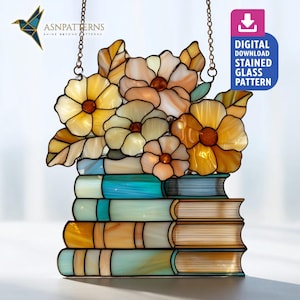 May include: Stained glass panel featuring a stack of books topped with flowers and leaves. The flowers are yellow, peach, and cream, with brown centers. The books are blue, cream, and orange. The panel is suspended by a chain and includes the text "DIGITAL DOWNLOAD STAINED GLASS PATTERN."