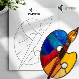 May include: A colorful stained glass palette and paintbrush are featured in this image. The palette is filled with vibrant hues of blue, red, orange, and yellow. The word "PAINTER" is printed on a white sheet of paper.
