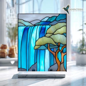 May include: Stained glass panel showing a waterfall and tree scene. The artwork uses blue, green, and brown hues. The panel is mounted on a white marble base. The text "ASNPatterns" is visible in the upper right corner.