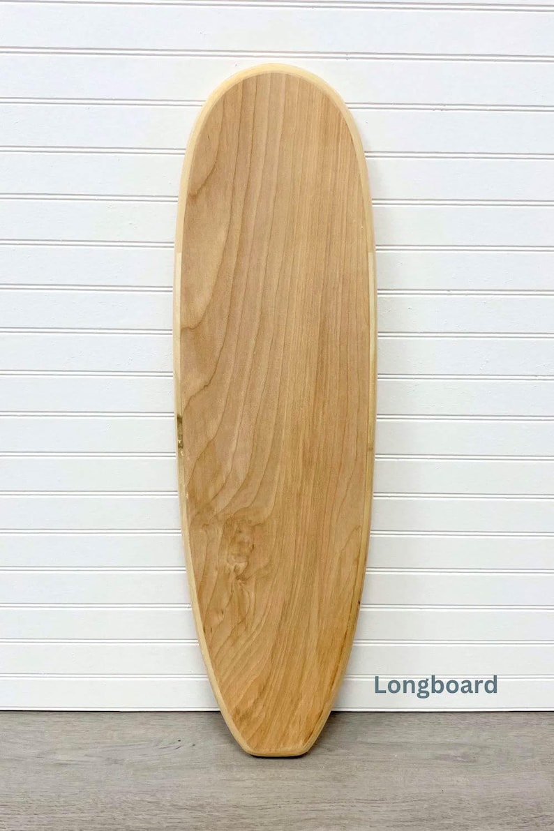 May include: A longboard made of natural wood. The board is light brown and has a smooth, rounded shape. The word "Longboard" is printed in blue text on the bottom right corner of the board.