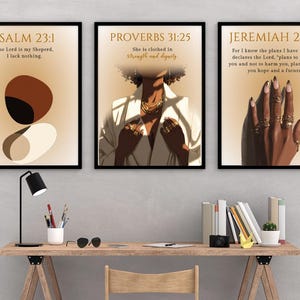 Peut inclure: Trois impressions d'art encadrées avec des cadres noirs. Les impressions présentent des citations inspirantes de la Bible. L'une des impressions présente des formes abstraites, une autre montre une personne en blazer blanc et la troisième affiche une main avec des bagues. Les impressions sont sur un bureau.