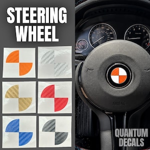 May include: A set of six circular steering wheel emblem decals featuring a quadrant pattern with carbon fiber texture in orange, silver, gold, red, blue, and black. One orange and white decal is applied to the center of a black car steering wheel.