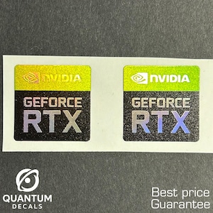 May include: Two NVIDIA GeForce RTX holographic stickers on a white backing. The stickers have a yellow and green top section with the NVIDIA logo, and the text "GEFORCE RTX" below. The bottom of the stickers have the text "QUANTUM DECALS".