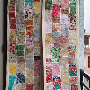 May include: Two long, rectangular wall hangings featuring a patchwork design of various fabric squares. Each square displays different embroidered patterns, floral motifs, and metallic thread accents in colors including pink, green, gold, and blue.