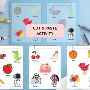 May include: A colorful cut and paste activity sheet for children. The sheet features various illustrations of objects like a ball, banana, ant, alligator, apple, cake, bird, and more. The text "CUT & PASTE ACTIVITY" is displayed prominently.