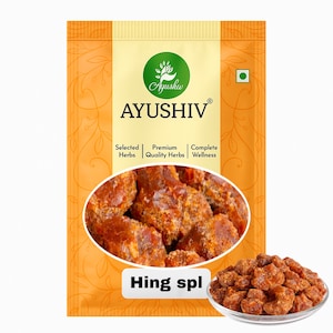 May include: A package of Ayushiv Hing spl, featuring a clear image of the product and a small bowl of the product. The packaging is orange and white with the Ayushiv logo and text.