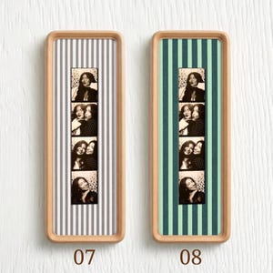Puede incluir: Dos marcos rectangulares de madera que contienen tiras de fotos verticales. El marco izquierdo presenta un fondo de rayas grises y blancas, mientras que el derecho tiene un fondo de rayas verde azulado y verde oscuro. Cada tira muestra cuatro fotos en blanco y negro.