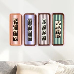 Puede incluir: Cuatro marcos rectangulares de madera con esquinas redondeadas, cada uno con una tira vertical de cuatro fotos de fotomat&oacute;n en blanco y negro. Los fondos detr&aacute;s de las tiras de fotos presentan rayas verticales en naranja, azul, morado y verde.