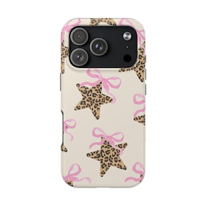May include: A phone case featuring a repeating pattern of leopard print stars tied with pink bows on a cream background. The case has a camera module with three lenses and a flash.