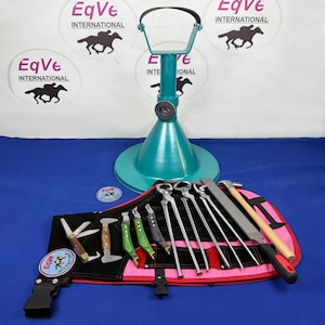 Peut inclure: Un support de maréchal-ferrant turquoise avec un dessus noir et un ensemble d'outils de maréchal-ferrant. Les outils comprennent des pinces, une râpe, un marteau et des couteaux. Les outils sont disposés sur un rouleau à outils noir et rose. Le logo "EqVe International" est visible.