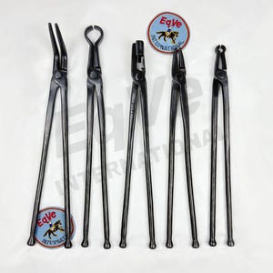 May include: A collection of black farrier tools, including nippers and tongs, arranged on a white surface. Two circular logo stickers with a horse and rider are also visible. The tools are designed for equine hoof care.