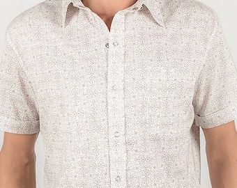 Peut inclure: Une chemise boutonnée à manches courtes blanche avec un petit imprimé sur toute la surface. La chemise a une coupe décontractée et un col.