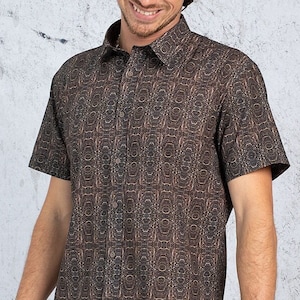 以下が含まれることがあります： 幾何学模様のブラウンの半袖ボタンダウンシャツ。ゆったりとしたフィット感と襟付きです。