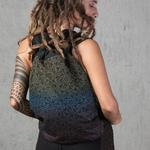 May include: A black backpack with a drawstring closure and a gradient design. The design transitions from yellow to blue, and then to black. The backpack has a repeating pattern of small, connected shapes.