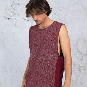 Puede incluir: Una camiseta sin mangas con fondo burdeos y un patr&oacute;n geom&eacute;trico blanco. La camiseta tiene un panel burdeos liso en el lado derecho.