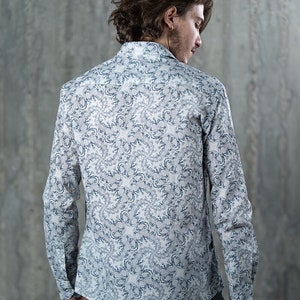 May include: A white long-sleeve shirt with a blue and white patterned design. The shirt has a button-down collar and a relaxed fit.