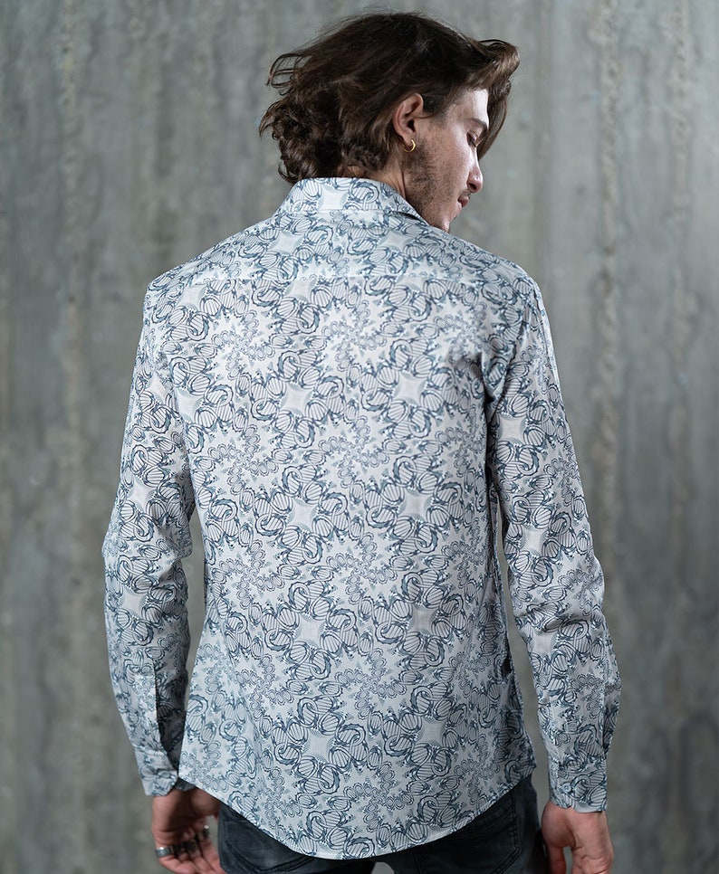 May include: A white long-sleeve shirt with a blue and white patterned design. The shirt has a button-down collar and a relaxed fit.