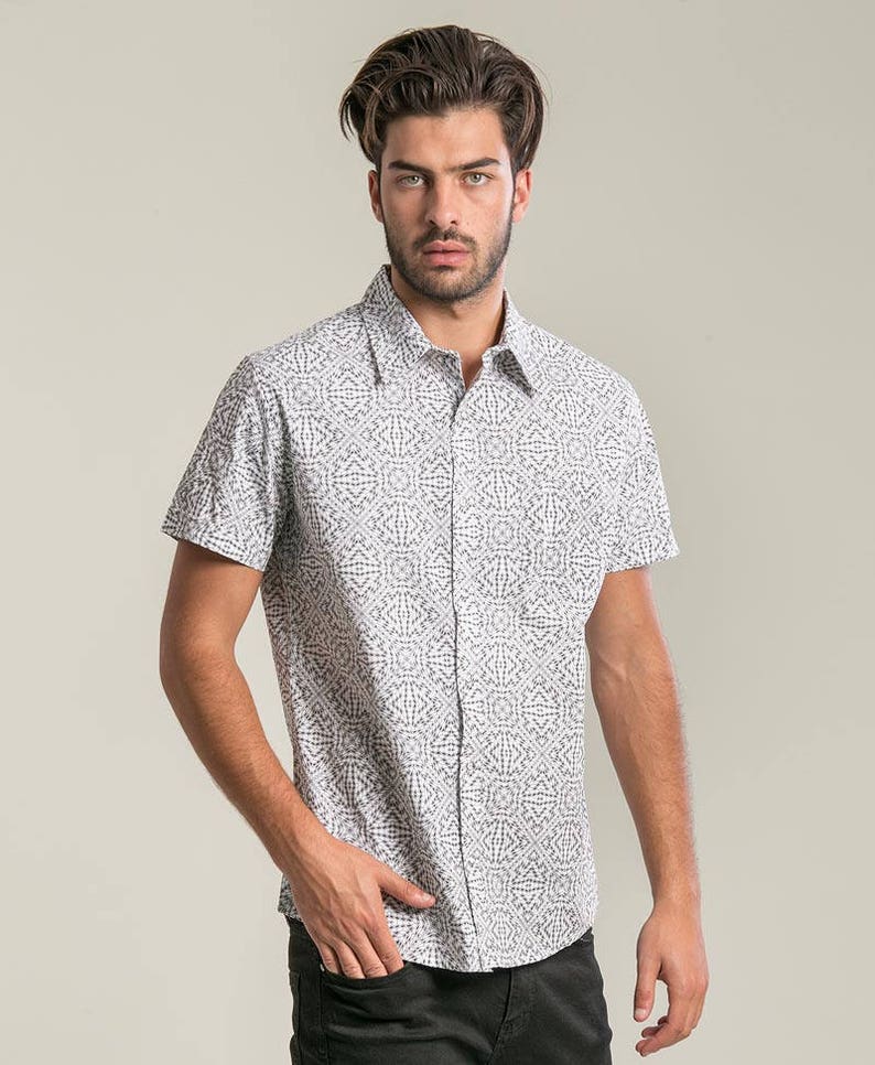 May include: A white short-sleeved button-down shirt with a black geometric pattern.