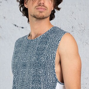 Puede incluir: Una camiseta sin mangas con un dise&ntilde;o estampado en blanco y azul. La camiseta tiene un cuello redondo y un ribete blanco en el lateral.