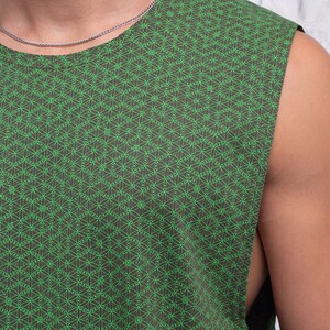 May include: A sleeveless shirt with a green and brown geometric pattern. The pattern is a repeating design of small circles and lines.