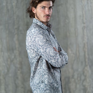 May include: A long-sleeved button-down shirt with a white background and a blue and gray floral pattern.