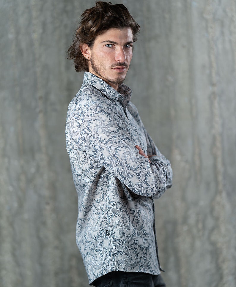 May include: A long-sleeved button-down shirt with a white background and a blue and gray floral pattern.